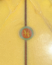Load image into Gallery viewer, Close-up of a yellow fabric with a circular emblem featuring a horse and text.