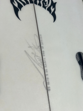 Load image into Gallery viewer, A close-up of a white surfboard with black graphic decals, fin hardware, and printed serial text
