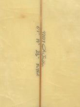 Load image into Gallery viewer, A close-up of a light beige surfboard with a vertical center seam and handwritten black ink measurements and notes running down the middle