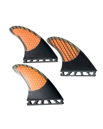 Three Future orange and black honeycomb patterned surfboard fins on a white background