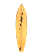 Load image into Gallery viewer, A vintage surfboard with a warm yellow-orange wood finish and a bold black lightning bolt graphic down the center, isolated on a white background.