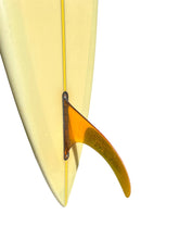 Load image into Gallery viewer, Close-up of a surfboard tail with a translucent orange fin attached, shown against a plain white background.