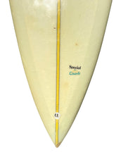 Load image into Gallery viewer, Close-up of the pointed nose of a vintage surfboard, showing a cream-colored foam grain surface with a yellow center stripe, the text 'Special Lisardi' in black and blue.