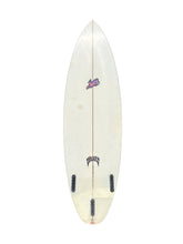 Load image into Gallery viewer, A miniature white surfboard toy with black foot pegs and small purple and black graphics, shown against a plain white background.
