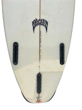 Load image into Gallery viewer, Close-up of the underside of a white surfboard with black fin hardware, a central vertical stringer, and a stylized black graphic near the top.