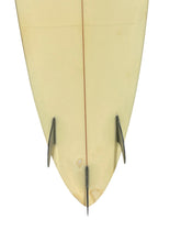 Load image into Gallery viewer, Close-up of the bottom half of a light cream or pale yellow surfboard, showing the center line, fins, against a plain white background.