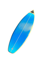 Load image into Gallery viewer, A long, narrow surfboard shown diagonally on a plain white background. The board is bright blue with a glossy finish, a thin white center string, a gold edge, and a small black-and-white logo near the pointed tail end.