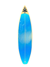 Load image into Gallery viewer, A long, narrow surfboard with a bright blue to cyan gradient top, a gold edge, and a black-and-white logo at the pointed nose, shown on a plain white background.