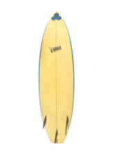 Load image into Gallery viewer, A vintage Al Merrick surfboard with a natural light wood top, blue edge striping, and black graphics, shown vertically against a plain white background.