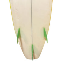 Load image into Gallery viewer, Close-up of the tail section of a surfboard showing a cream-colored deck with green fins and a thin yellow edge line against a white background.