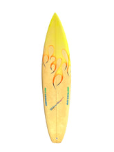 Load image into Gallery viewer, A custom yellow surfboard with orange and black flame graphics and blue text, shown vertically against a plain white background.