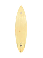 Load image into Gallery viewer, A IG surfboard with a light colored finish, featuring a pointed nose, a center rail, and a black signature near the tail, shown against a plain white background.