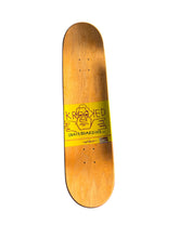 Load image into Gallery viewer, A wooden skateboard deck with a natural light brown wood grain finish, featuring a bright yellow graphic sticker in the center with the text 'KROOKED SKATEBOARDING' and a cartoon face graphic.
