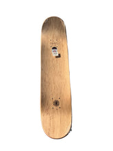 Load image into Gallery viewer, A wooden skateboard deck with a natural light brown wood grain finish, featuring a small sticker near the front and a circular logo near the tail, shown against a plain white background.