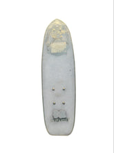 Load image into Gallery viewer, A translucent light gray acrylic or resin skateboard deck insert with a gold-toned graphic near the nose, four metal screw holes, and a small dark logo near the tail, shown on a plain white background.