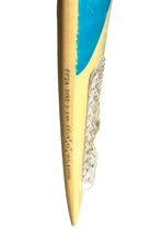 Load image into Gallery viewer, A close-up of a surfboard with a bright blue painted section, natural wood grain, printed black model number 'FZPA 5085', and a textured clear protective cover on the right side, isolated on a white background.