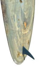 Load image into Gallery viewer, Close-up of the tail section of a vintage surfboard, showing a light blue and beige marbled underside with a dark blue fin, isolated on a white background.