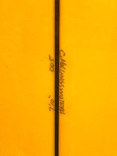 Load image into Gallery viewer, A close-up of a bright yellow-orange surface with a vertical dark line running through the center and handwritten text near the middle.